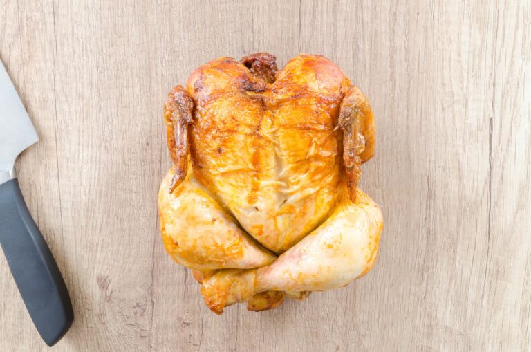 Poulet rôti entier doré et croustillant sur un plat de service